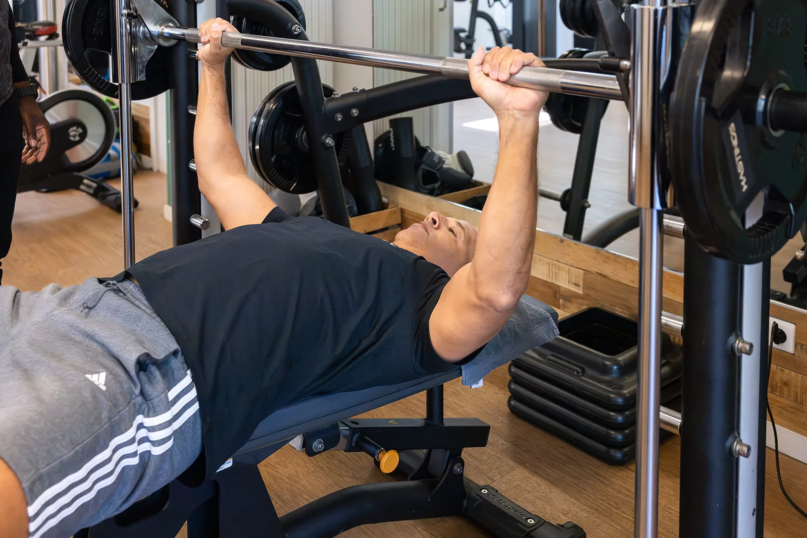 Coach begeleidt een cliënt tijdens krachttraining